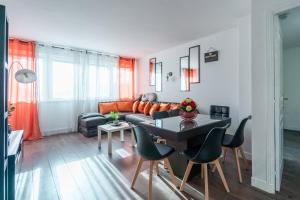sala de estar con sofá y mesa en Sunrise - Bel apt 2 chambres, en LʼHay-les-Roses