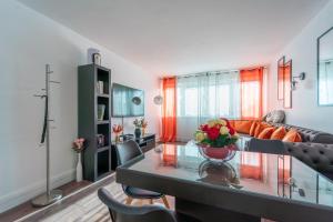 uma sala de estar com um sofá e uma mesa em Sunrise - Bel apt 2 chambres em LʼHay-les-Roses