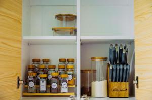 a cupboard filled with lots of bottles and utensils at Bohemian Coast at Azure North in Lagundi
