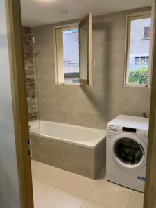bagno con vasca e lavatrice. di APPARTEMENT 3 CHAMBRES A LA MONTAGNE a Saint-Michel-de-Maurienne