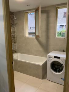 a bathroom with a tub and a washing machine at APPARTEMENT 3 CHAMBRES A LA MONTAGNE in Saint-Michel-de-Maurienne