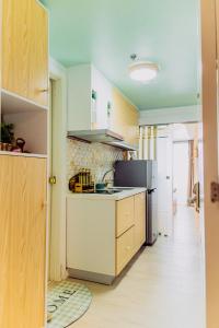 a kitchen with wooden cabinets and a refrigerator at Bohemian Coast at Azure North in Lagundi