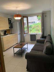 un soggiorno con un divano e un tavolo di APPARTEMENT 3 CHAMBRES A LA MONTAGNE a Saint-Michel-de-Maurienne Altre 8 foto