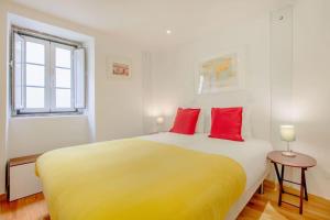 リスボンにあるAlfama Charming Apartmentのベッドルーム1室(大型ベッド1台、赤い枕2つ付)