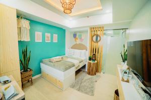 een slaapkamer met een bed en een blauwe muur bij Bohemian Coast at Azure North in Lagundi
