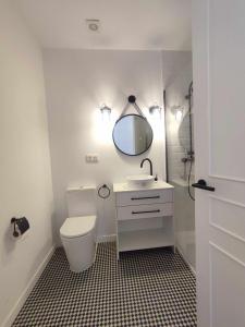 uma casa de banho com um WC, um lavatório e um espelho. em Calle Real con patio em Ferrol