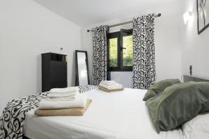 a bedroom with a white bed with towels on it at Ca na Carmen -Crestatx- in Crestatx +24 photos