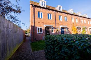 a large brick building with a fence in front of it at Perfect Stay Rugby in Rugby