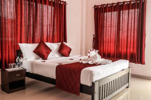瓦戈曼的住宿－towersky hill resort CONCERN OF PINKY HOLIDAYS，一间卧室配有红色窗帘的床