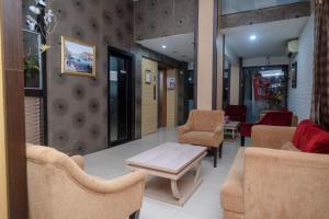 a waiting room with chairs and a table in a room at RedDoorz Plus At Grand Populer Hotel in Makassar