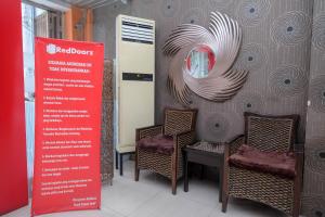 a wall with chairs and a sign in a room at RedDoorz Plus At Grand Populer Hotel in Makassar