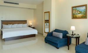 a bedroom with a bed and a blue chair at Black Diamond Hotel in Lagos