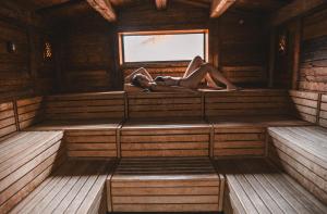 a woman is laying in a sauna at Les Violettes Hotel & Spa in Jungholtz