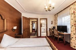 Cette chambre comprend un lit et un bureau. dans l'établissement Hotel Elisabeth, à Schoppernau