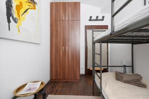Vienna City Business Rooms في فيينا: غرفة نوم مع سرير بطابقين وخزانة خشبية