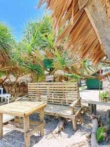 GubatにあるDagat-Dagatan Beach House Bungalow Resthouse Gubatの木製のベンチと小屋の前のテーブル