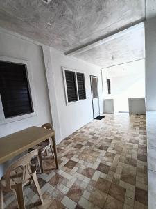 comedor con mesa y sillas en Dagat-Dagatan Beach House Bungalow Resthouse Gubat, en Gubat