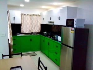 una cucina con armadi verdi e frigorifero di HomeStay Private Home a Suva