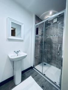 a white bathroom with a shower and a sink at Stunning 3-Bed Cottage in Gateshead in Gateshead
