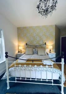 a bedroom with a white bed with a chandelier at Stunning 3-Bed Cottage in Gateshead in Gateshead