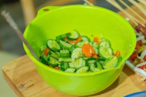 un tazón verde lleno de verduras en una tabla de cortar en Su's Villa Hà Giang - Biệt thự nguyên căn tại trung tâm thành phố Hà Giang en Ha Giang