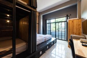 - une chambre avec des lits superposés et un bureau dans l'établissement Joox B - Serviced Apartment, à Betong