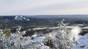 a snow covered tree on top of a mountain at Asuntovaunu Hobby in Syöte