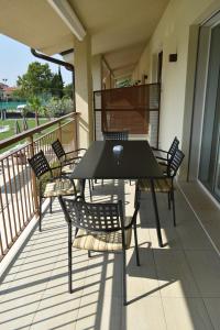 a black table and chairs on a balcony at Residence La Magnolia - Aparments in Lazise