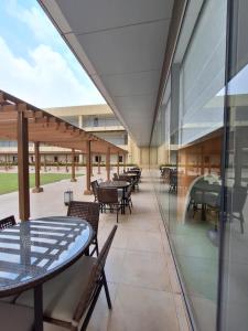 an empty cafeteria with tables and chairs and windows at Moslem Friendly 1BR Branz BSD, Near AEON Mall & ICE in Samporo