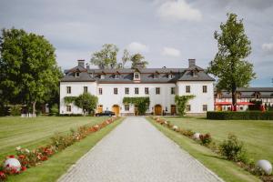 ein großes weißes Haus mit Auffahrt in der Unterkunft Pałac Pakoszów Schlosshotel Wernersdorf in Jelenia Góra