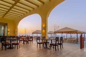restauracja ze stołami i krzesłami oraz widokiem na ocean w obiekcie Siva Golden Bay Makadi w mieście Hurghada
