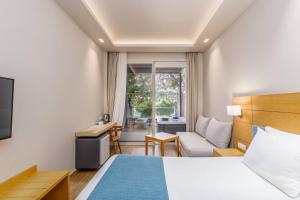 a hotel room with a bed and a couch at Akrotiri Beach Resort Hotel - Adult Friendly in Paleokastritsa +37 photos