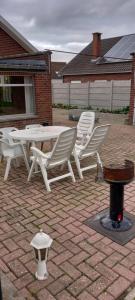 una mesa blanca y sillas en un patio de ladrillo en Wenceslas Cobergher IV en Bertem
