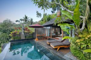eine Villa mit einem Pool und einem Haus in der Unterkunft Black Penny Villas Ubud in Ubud