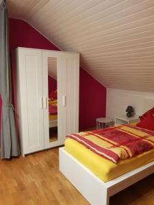 1 dormitorio con 1 cama y armario blanco en Ferienwohnung Hedi, en Mertloch