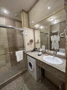 a bathroom with a sink and a washing machine at CITY STAY Апарт-Отель Алматы in Almaty