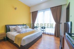 a bedroom with a bed with yellow walls and a television at LuxegreenRetreat , Bungalow - Georgetown, Penang in George Town