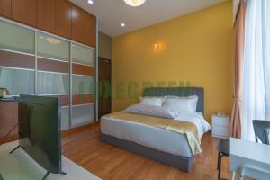 a bedroom with a bed and a flat screen tv at LuxegreenRetreat , Bungalow - Georgetown, Penang in George Town
