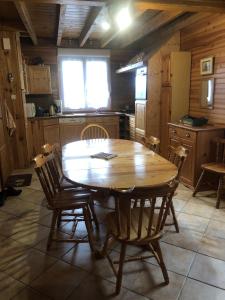 eine Küche mit einem Holztisch und Stühlen in der Unterkunft Maison Sur 2 Niveaux in Nance