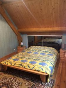 ein Schlafzimmer mit einem Bett im Dachgeschoss in der Unterkunft Maison Sur 2 Niveaux in Nance