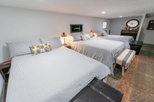 um quarto com 3 camas e lençóis brancos em Mom & Pop's: Waterfront,Nature,Togetherness em Cambridge Springs