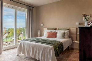 a bedroom with a large bed and a large window at I Ciabot di Monforte in Monforte dʼAlba
