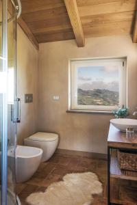 baño con aseo y lavabo y ventana en I Ciabot di Monforte, en Monforte dʼAlba
