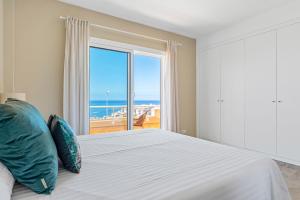um quarto com uma cama e uma grande janela em Casa Mila: Encanto con Vista al Mar em Puerto de Santiago
