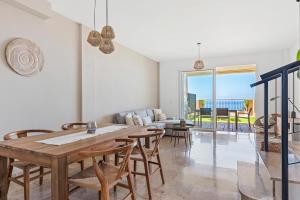 uma sala de estar com uma mesa de madeira e cadeiras em Casa Mila: Encanto con Vista al Mar em Puerto de Santiago