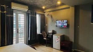 a room with a kitchen with a desk and a refrigerator at Happy Hotel in Ho Chi Minh City