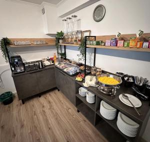 a kitchen with a counter with food on it at Hotel PASO in Cluj-Napoca