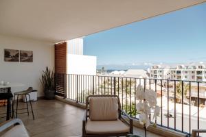 a balcony with a chair and a view of a city at Hotel Le Saint Pierre ÎLe De La Reunion. in Saint-Pierre