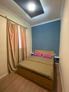a bedroom with a bed with two pink pillows at Paronyan hostel in Yerevan