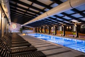 a swimming pool with benches in a building at Hotel Putnik Kopaonik in Kopaonik